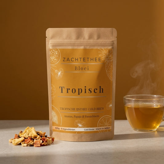 Bloei Tropisch losse thee in kraft doypack op amberkleurige achtergrond, met gedroogde ananas en papaja en een glas honinggouden thee